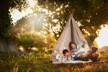 Teepee, kids and playing in garden tent outdoor in nature for camping, fun and adventure with...