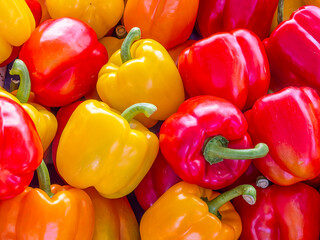Red, yellow and orange bell peppers for sale at the local market. Colorful, natural pattern top...