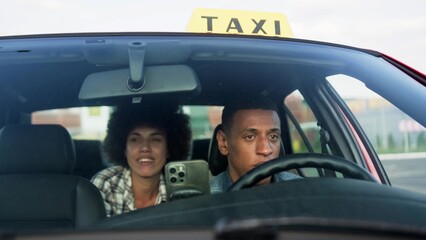 Young lady talking to taxi driver while sitting at backseat in the car. Yellow taxi car roof sign. People, job, service concept.