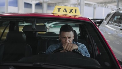 Male taxi driver sitting in the car and coughing.