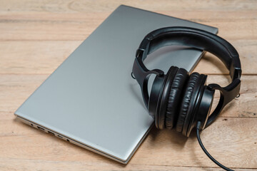 headphones and laptop on wooden table