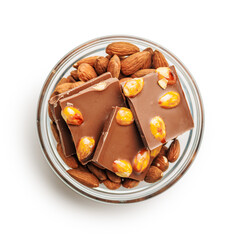 Broken chocolate bar with almonds in bowl isolated on white background.