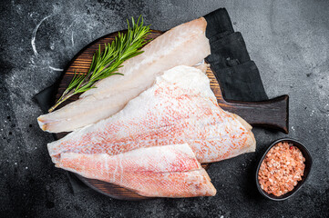 Fresh Raw red perch fillet, Snapper fish on a wooden board. Wooden background. Top view