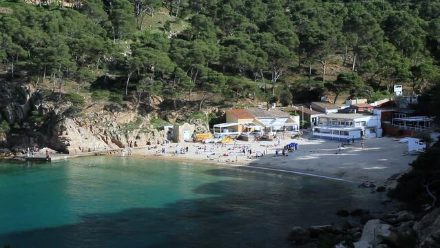 General view of the cove of Aiguablava with people bathing at sunset. Begur, Costa Brava, Catalonia, Spain.