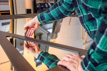 cutting glass in a glass factory, Glazier cuts mirror panes using a hand cutter, Industrial concept