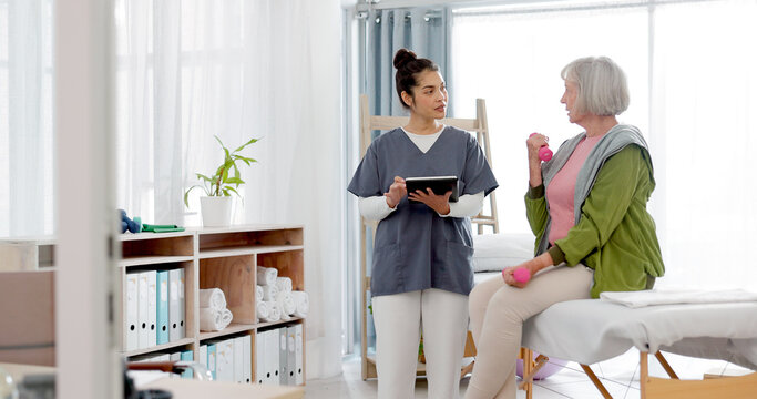 Senior woman, physiotherapy and tablet for support, dumbbell exercise and physical therapy exam. Physiotherapy, chiropractor and fitness of elderly person and nurse on digital technology for progress
