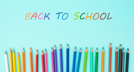 Color pencils collection in a row, back to school, drawing supplies, blue background with copy space