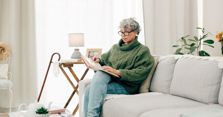 Woman reading funny book in living room for story, novel and knowledge in retirement. Happy senior...