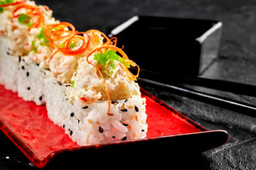 Sesame coated roll with creamy seafood topping and green tobiko