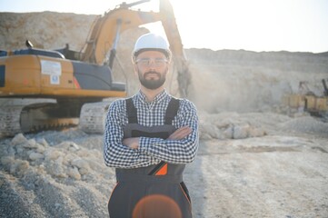 Worker in hardhat standing in stone quarry