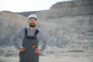 Portrait of a worker standing on the background of a stone quarry