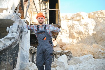 Fototapeta na wymiar Extraction of stone. Male worker next to stone quarry. Engineer at construction site