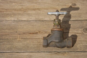 old water faucet. old cast iron water tap on a wooden background. selective focus.