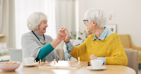 Senior woman, friends and high five for chess match, game or winning on table together at home....