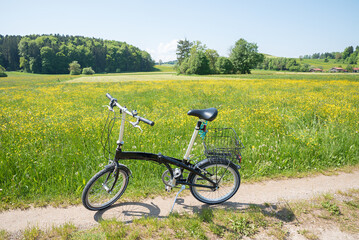 bike route around lake Seehamer See, buttercup meadow. folding bike on the way. landscape bavaria