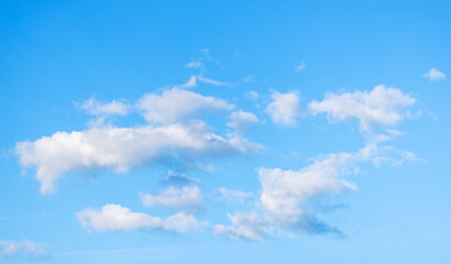 Group of white clouds fly in bright blue sky. Natural background photo