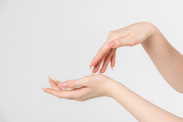 Close-up side view of elegant female hands touching each other during dance against grey...