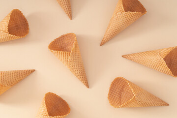 Pattern composition made of ice cream cones on pastel cream background. Summer creative concept....
