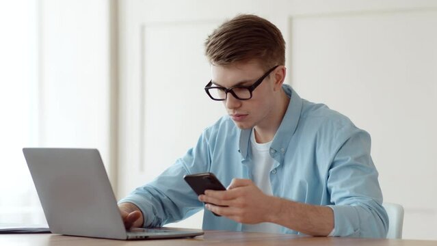 Mobile banking and two factor authentication. Young man entering credit card data and security password from cell phone on laptop at home workplace