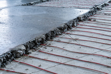 Pouring mortar along the beacons of electric cables of underfloor heating.