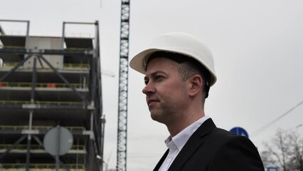 Insightful perspective Architect in business attire and white helmet assesses site plans with keen precision. Architect embodies professional acumen, manifesting architect's analytical skill