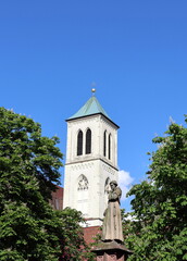 Turm der Martinskirche in Freiburg zwischen blühenden Kastanien