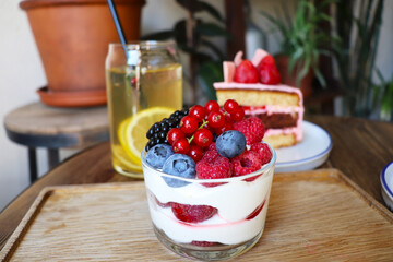 summer dessert with berries and cream and homemade lemonade on a wooden table