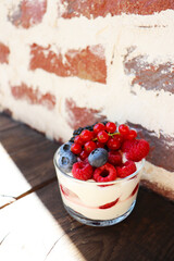 summer dessert with berries and cream and homemade lemonade on a wooden table