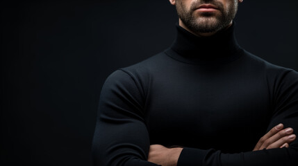 Muscular man in a black turtleneck, with his arms crossed, partially obscured by shadows, exuding confidence and mystery.