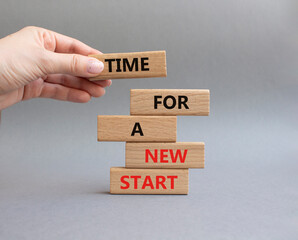 Time for a new start symbol. Wooden blocks with words Time for a new start. Beautiful grey...