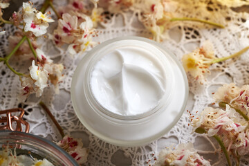 Horse chestnut cream in a glass jar with freh Aesculus hippocastanum flowers