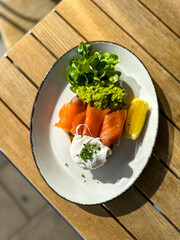 Healthy food. Toast with avocado, smoked salmon and poached eggs. Breakfast at lunch in a cafe