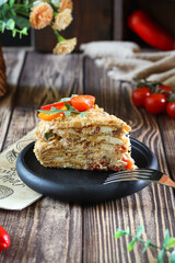 A slice of savory pie topped with fresh tomatoes and arugula on a rustic plate.