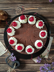 Beautifully styled chocolate cake with creamy swirls and glossy cherries, perfect for a feast.