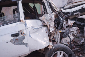 Wrecked passenger car. Auto graveyard. Damaged vehicles. Car after an accident.