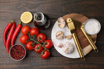 Different fresh ingredients for marinade and garlic press on wooden table, flat lay