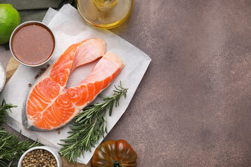Fresh fish, products and marinade on brown textured table, flat lay. Space for text