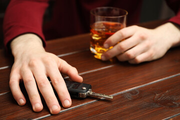 Drunk man reaching for car keys at table, closeup. Don't drink and drive concept