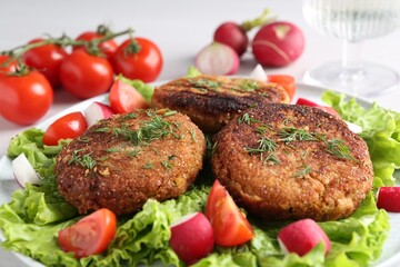 Delicious vegetarian cutlets and vegetables on plate, closeup