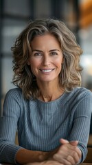 Fototapeta premium A woman with a smile on her face is sitting at a table, looking content and relaxed