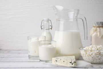 Different fresh dairy products on white wooden table. Space for text