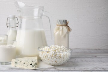 Different fresh dairy products on white wooden table. Space for text