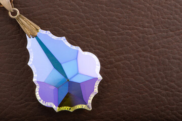 Crystal positioned on brown leather surface, selective focus