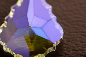Crystal positioned on brown leather surface, selective focus
