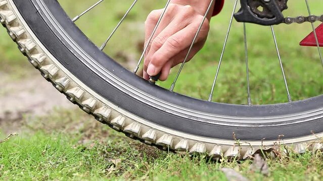 Girl inflates tire with small hand pump in a bicycle.The topic is amateur bicycle maintenance, repair and adjustment.