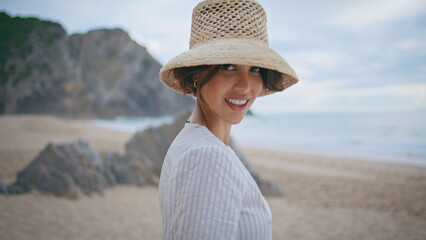 Sensual brunette posing beach at cloudy ocean closeup. Smiling lady enjoy shore