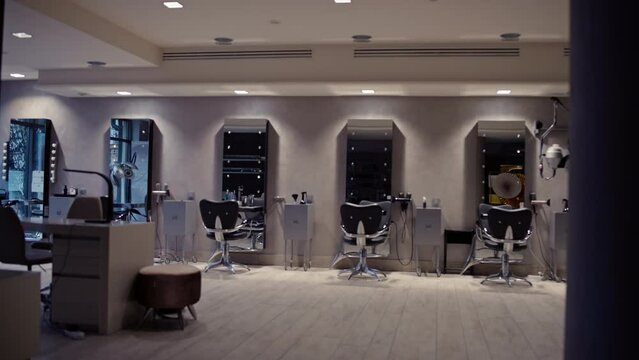 The light turns on in the barbershop hall. Background video of the interior of a barbershop with chairs and mirrors. High quality 4k footage