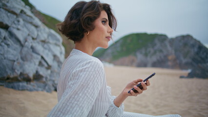 Lady holding smartphone beach on weekend closeup. Stylish woman resting ocean