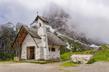 Fototapeta na wymiar Small chapel in Falzarego pass in Dolomites. church in the mountains. Mountain chapel in Dolomites, Tre Cime di Lavaredo National Park, Italy