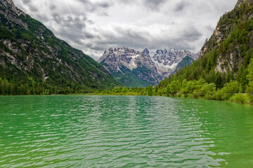 Green lake in the heart of the Dolomite Mountains. Moody landscape with turquoise water alpine lake...